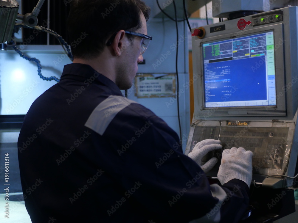 Fototapeta premium Factory engineer inspecting machining process on CNC machine in automotive manufacturing plant