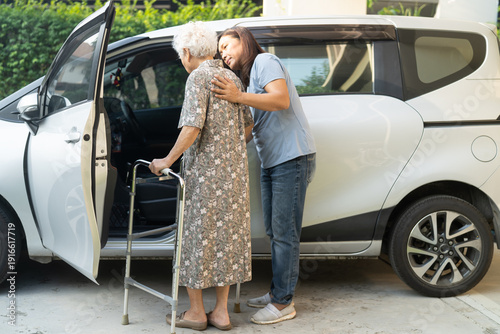 Caregiver help Asian elderly woman disability patient get into car.