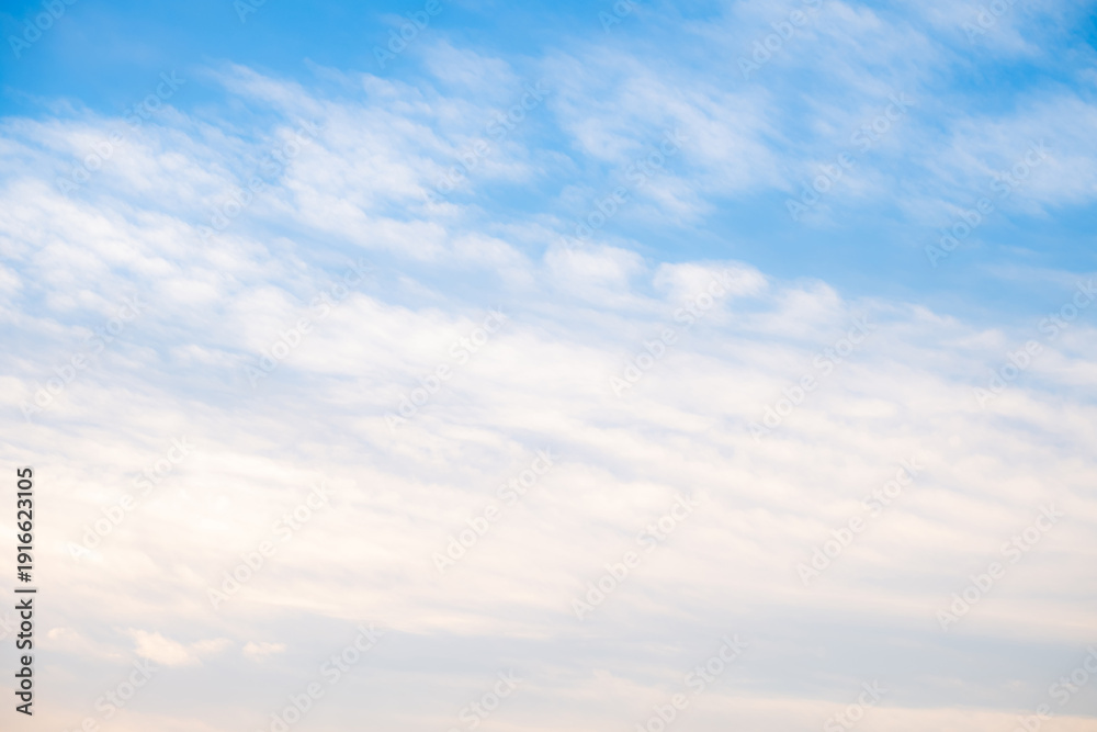 Fototapeta premium Beautiful blue sky background with soft white clouds and natural morning sunlight. Bright heaven landscape for summer seasonal design, weather forecast, and spiritual concept