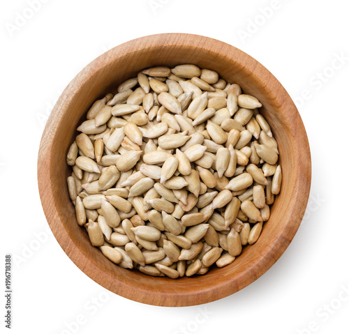 Peeled sunflower seeds, sunflower kernel in a wooden plate on a white background. Top view