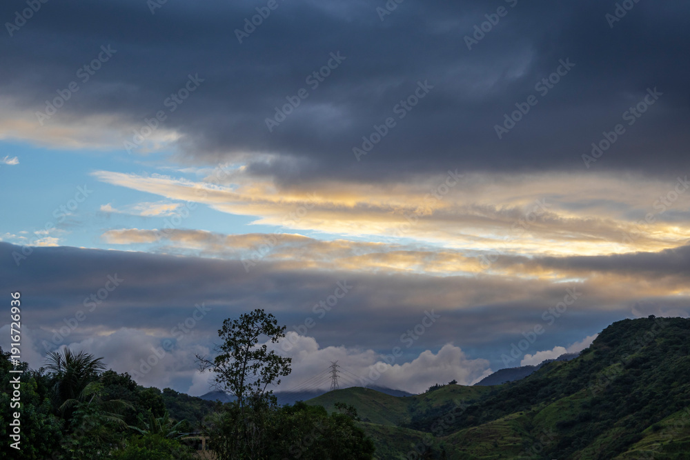 Fototapeta premium Late afternoon landscape with cloudy skies over mountains in the western region of Rio de Janeiro, Brazil.