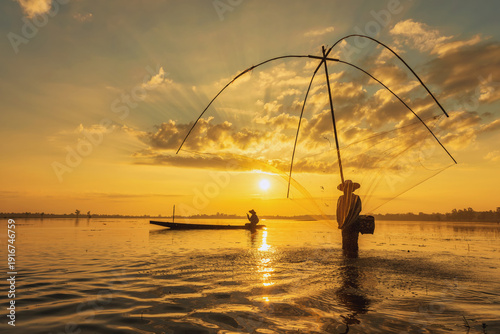 Silhouetted Laguna fisherman casts net at sunset