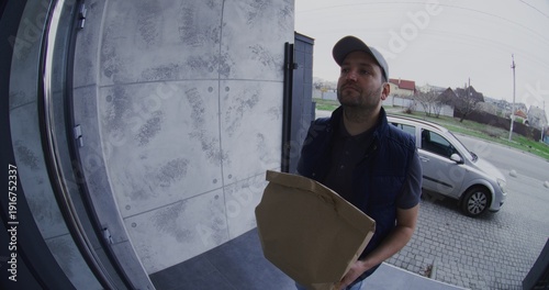 Fényképezés Doorbell View of Tattooed Courier Delivering Paper Bag