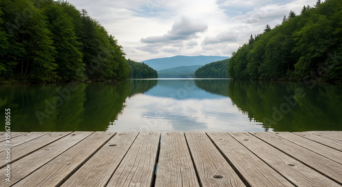 A serene lake surrounded by lush green trees and a wooden dock