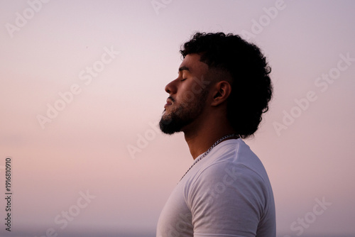 Young man meditating, finding calm and relaxation