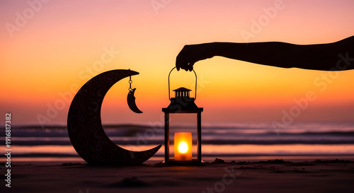 Silhouette of a hand lighting a lantern on a beach at sunset
