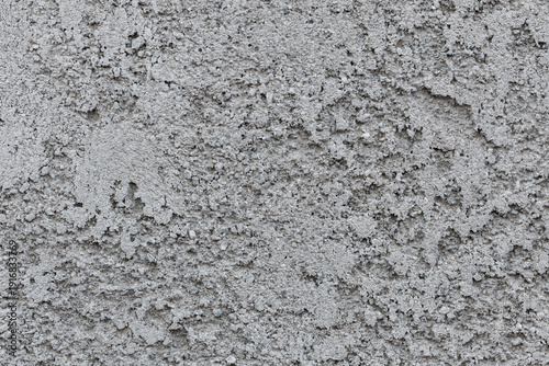 Fotografia Gritty wall texture with embedded aggregates, suitable for construction materials, raw surfaces, and industrial backgrounds