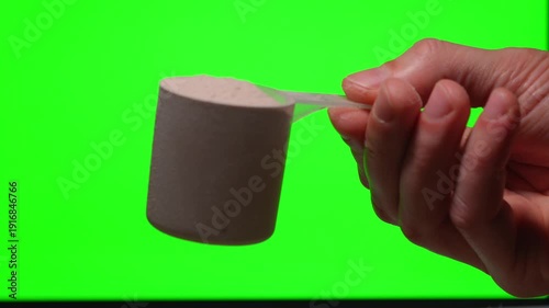 An athlete's hand holding a scoop of protein against a green background.
Nutrition for muscle growth.
Healthy dietary supplements.
Close-up of a scoop of protein
