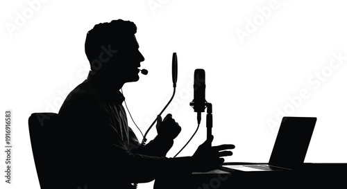 Silhouette of a male podcaster speaking into a headset and studio microphone with a laptop