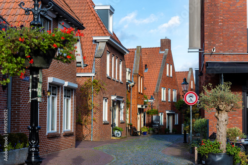Cuadro en lienzo Historic street Ootmarsum brick houses red rooftops cobblestone pavement curving through quiet village center