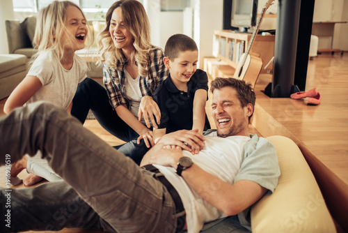 Photos Parents and kids laughing and tickling in the living room