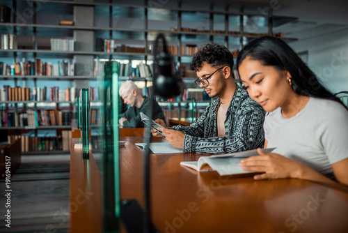 Young students studying with books in university library