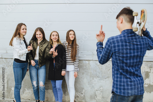 Photos Teenagers showing middle finger gesture to a young man holding a skateboard, con