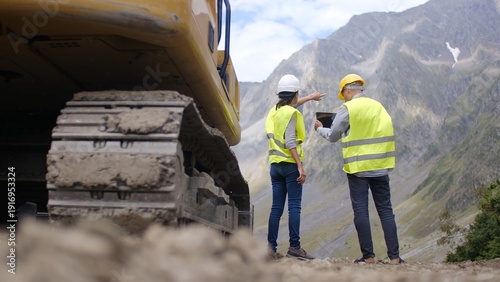 Tableau sur toile Construction workers and engineers discussing project plans using a digital tabl