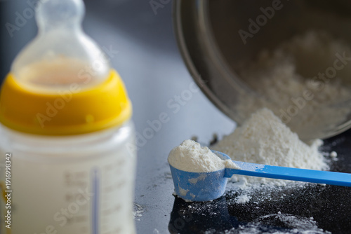 Baby formula, infant formula, baby milk bottle, scoop of milk powder, tipped-over can