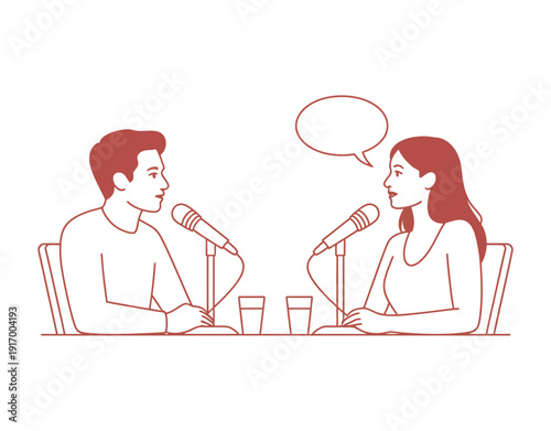 A man and woman sitting at a table with microphones, engaged in a conversation
