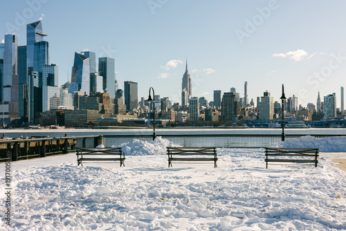 Εκτύπωση καμβά Snow covers the ground as benches sit empty near the waterfront in New York City