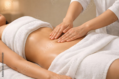 Close-up of therapist hands performing abdominal lymphatic drainage massage on a woman during a spa wellness treatment