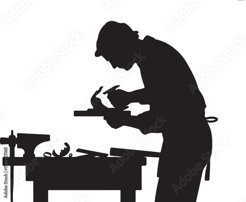 Silhouette of a person carving wood at a workbench
