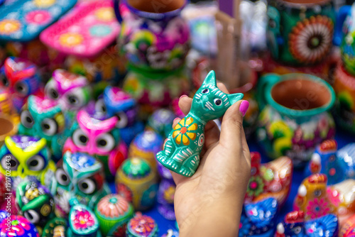 Foto A hand holds a colorful, handcrafted ceramic cat figurine