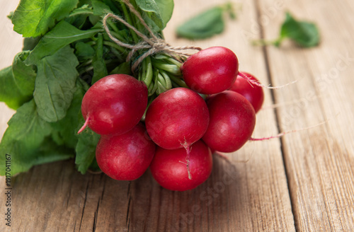 Fresh radishes bunch with green leaves on wood table