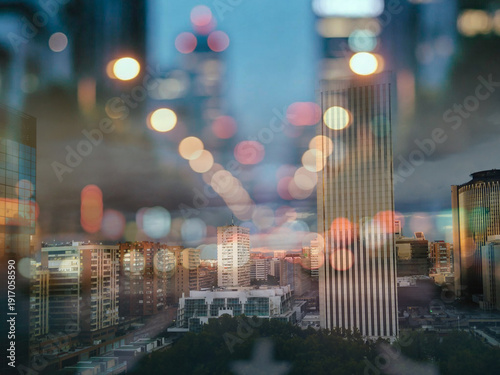 Abstract city skyline at dusk with double exposure bokeh lights effect and modern skyscrapers
