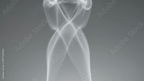 Twisting smoke streams. Multiple smoke streams twist together briefly before separating and dissolving into the surrounding air.