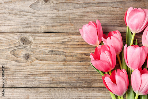 Bouquet of beautiful pink tulips on wooden table, top view. Space for text