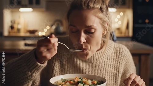 Woman enjoying a meal indoors with warm lighting
