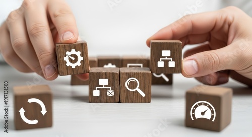 Workflow optimization icons on wooden cubes being positioned carefully with natural focus falloff and white minimal background blur.