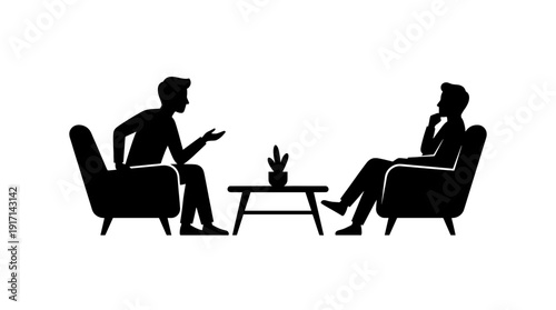 Two individuals engaged in a discussion while seated in armchairs, centered around a small table with a plant