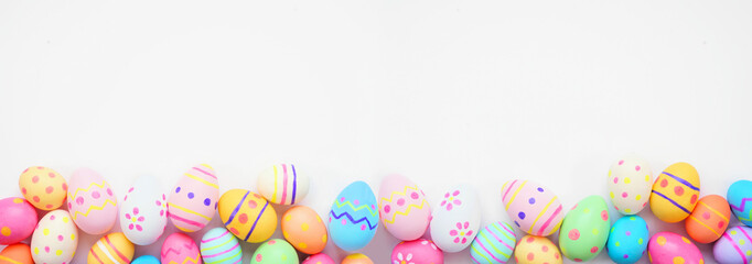 Colorful Easter Egg bottom border against a white banner background. Top view with copy space.
