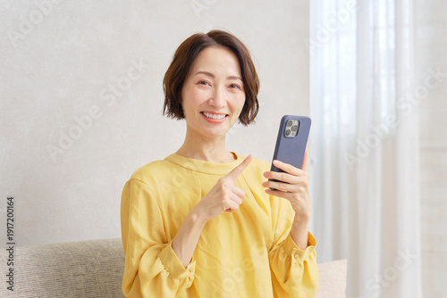 Wallpaper Mural リビングでスマートフォンを使う女性　ポートレート　カメラ目線 Torontodigital.ca