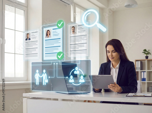 HR professional uses digital tablet and holographic interface for modern recruitment, reviewing virtual resumes, and managing talent with AI-powered tools in an office.