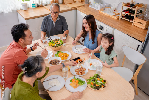 Quadro su tela Asian loving family spending quality time, having dinner in cozy house