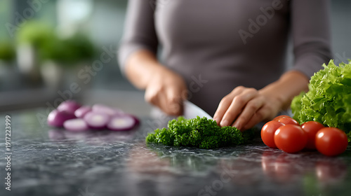 Woman cutting vegetables on the counter, with tomatoes and onion beside her