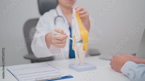 Doctor with Human Knee joint anatomy model. Osteoarthritis, Patellofemoral Pain Syndrome, Patellar Tendinitis, ACL, Anterior Cruciate Ligament, PCL, Posterior, MCL, Medial Collateral, LCL and Lateral