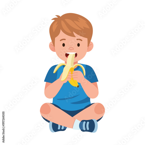 A young boy sitting cross-legged eating a banana with a big smile on his face