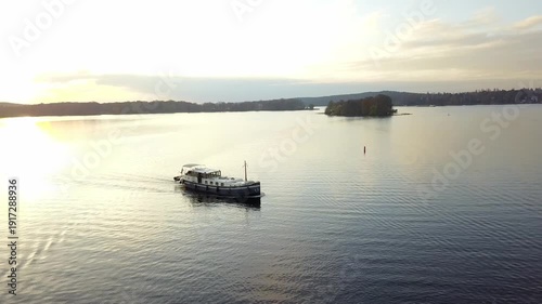 Wallpaper Mural Drone semi orbit around passenger river boat Luxemotor sailing across still lake with soft sunset light and distant island on horizon. Torontodigital.ca