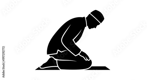 A man is kneeling on a mat in a prayer position