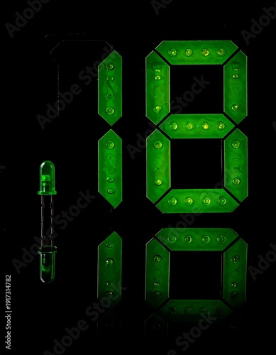 Wallpaper Mural Illuminated green numbers 18 with a reflection. A single green LED is present to the left of the numbers on a black background Torontodigital.ca
