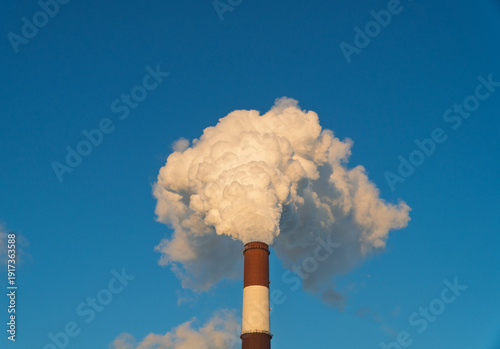 Foto Smoking chimney releasing smoke against a winter sky