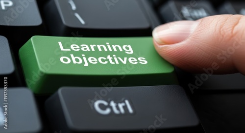 Finger Pressing Green Learning Objectives Button on Computer Keyboard