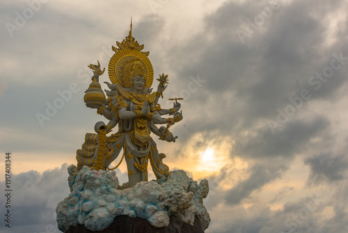 Wallpaper Mural Majestic Multi-Armed Hindu Deity Statue Under Dramatic Clouds – Bali Spiritual Power Torontodigital.ca