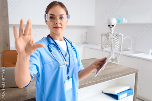 Female doctor in goggles with tablet computer using virtual screen at hospital