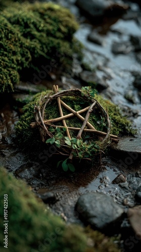 A pentagram crafted from twigs rests on wet earth, illuminated by soft natural light filtering through dense foliage