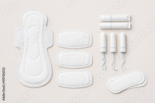 Collection of sanitary pads and tampons neatly arranged on a soft beige background, illustrating choice, protection and discreet feminine hygiene solutions.