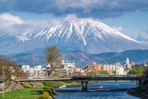 Buildings and promenade and riverside walkway at Katakami riverflowing through the middle of Morioka city, Iwate Cityscape  with Iwate Mount Background scene in Morioka,  Iwate, Japan