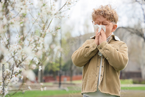 Sick little boy with tissue...