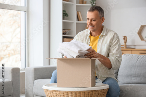 Mature man unpacking box wi...